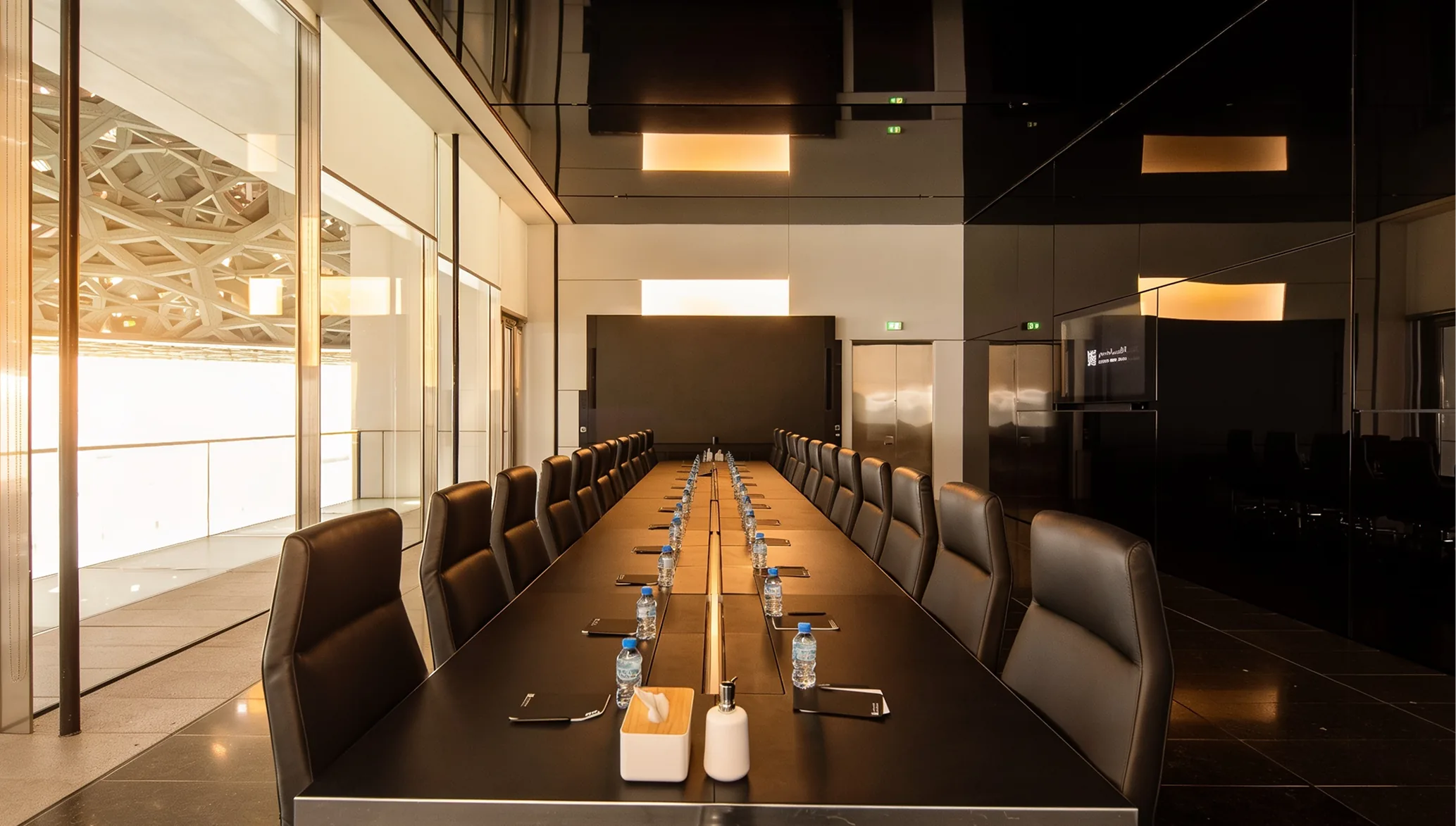 A meeting room at the Louvre Abu Dhabi, the dome's lattice visible through the glass