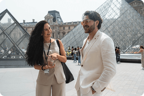 Two guests talking beside the Louvre pyramid